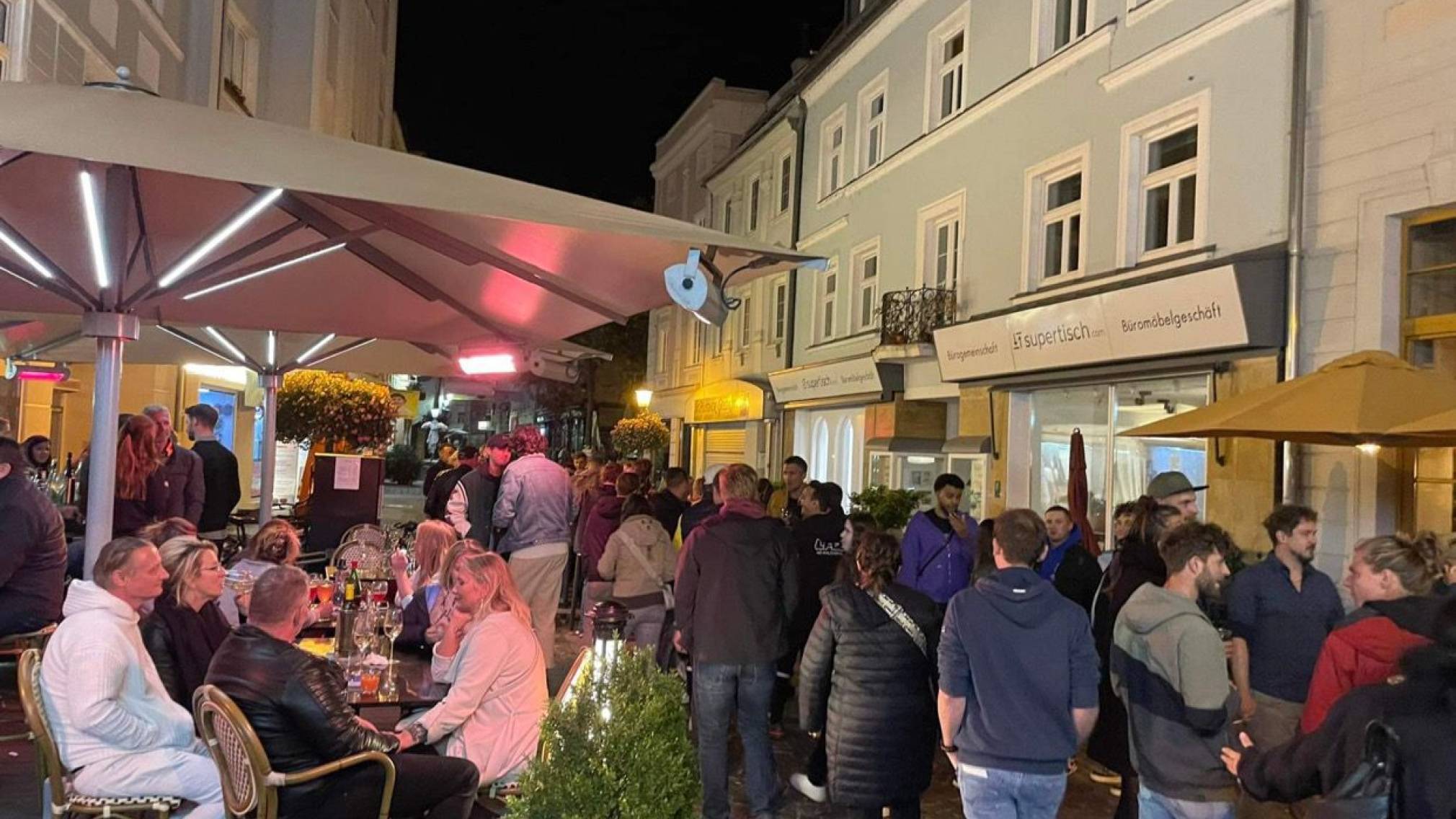 Zahlreiche Menschen stehen abends vor dem Weinlokal Vino in der schön beleuchteten St. Pöltner Innenstadt. Foto: Patrick Salfinger Fotografie